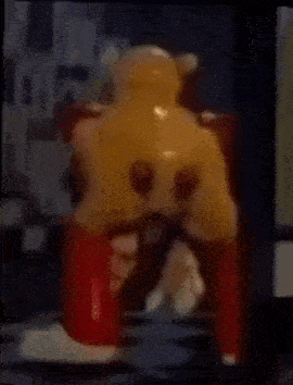 a toy bear is sitting on top of a red chair .