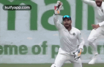 a man in a white shirt is jumping in the air while holding a bottle .
