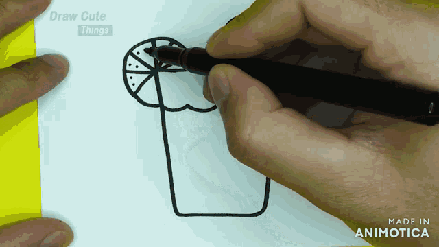 a person is drawing a cup with a lemon slice on it