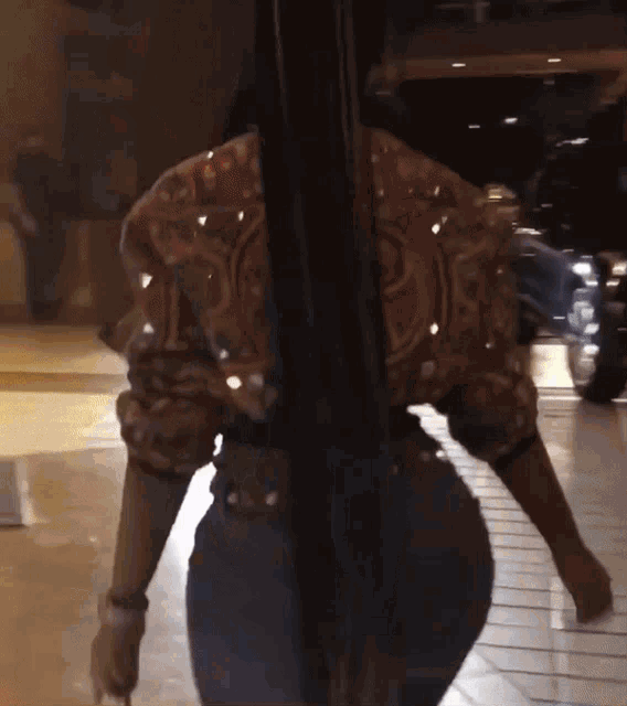a woman in a sequined jacket is standing in a doorway