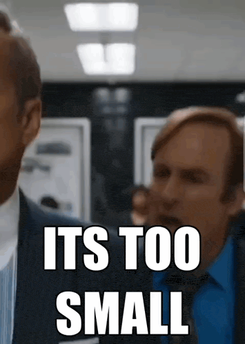 a man in a suit says it 's too small in front of another man in a blue shirt