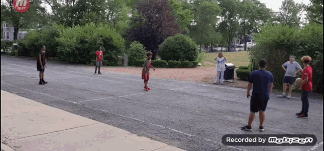 a group of people are playing a game of basketball in a parking lot and the video is recorded by mobizen