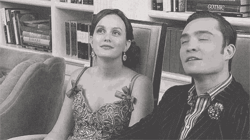 a man and a woman are sitting next to each other on a couch in a living room .