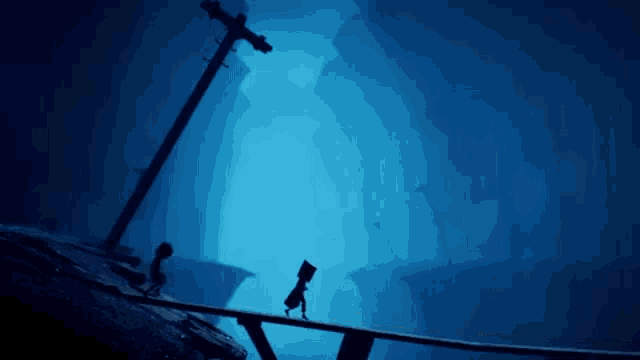 a couple of people are standing on a bridge in a dark tunnel .