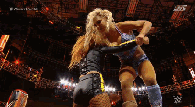 two women are wrestling in a ring with the words # winner take all on the screen