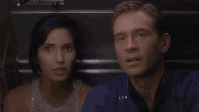 a man and a woman are looking at each other with their eyes closed in a dark room .