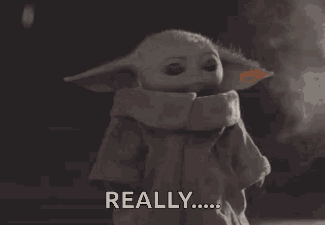 a baby yoda says " really " in a dark room