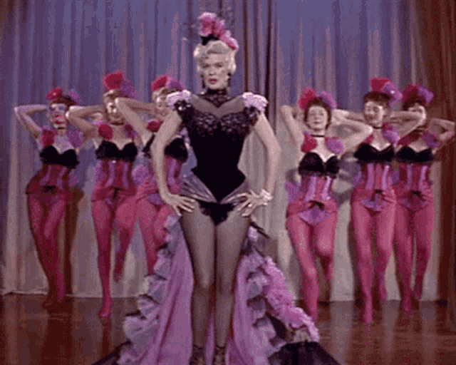 a woman in a purple dress is surrounded by other women