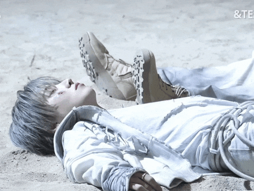 a person laying on a sandy surface with the word te on the bottom