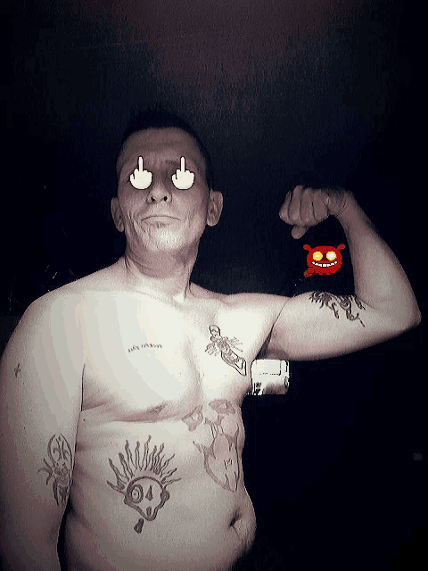a shirtless man flexes his muscles and has a tattoo of a skull on his chest and another on his arm
