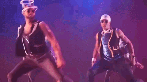a man in a top hat and sunglasses is dancing on a stage