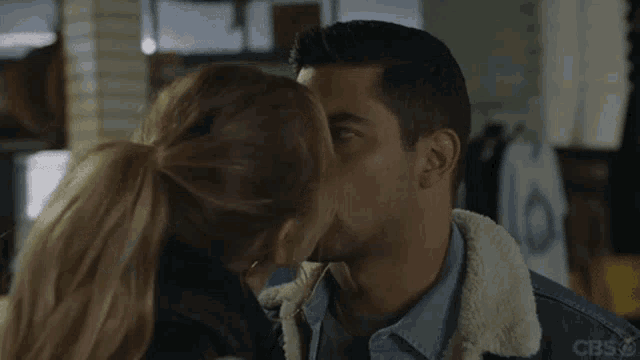 a man in a denim jacket is making a funny face in a room .