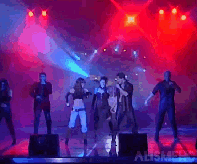 a group of people are dancing on a stage with the words alismehc on the bottom right