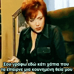 a woman with red hair is sitting in a chair with a foreign language written on it .