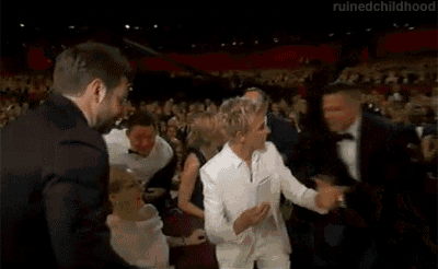 a group of people are standing around a woman in a white suit .