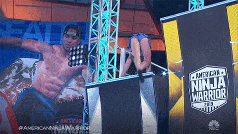 a man and a woman are on a stage in front of a sign that says american ninja warrior 2019