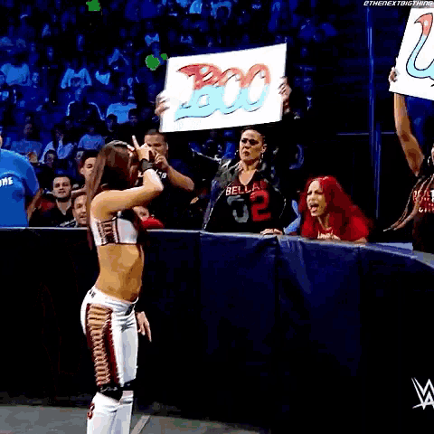 a woman is holding a sign that says boo while standing in front of a crowd .