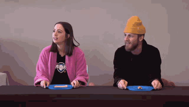 a man and a woman are sitting at a table with plates of food on it
