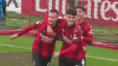 a group of soccer players wearing emirates fly better jerseys