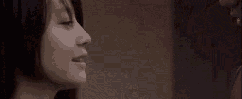 a man and a woman are looking at each other and kissing .