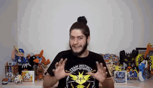 a man wearing a black shirt that says team instinct is making a funny face