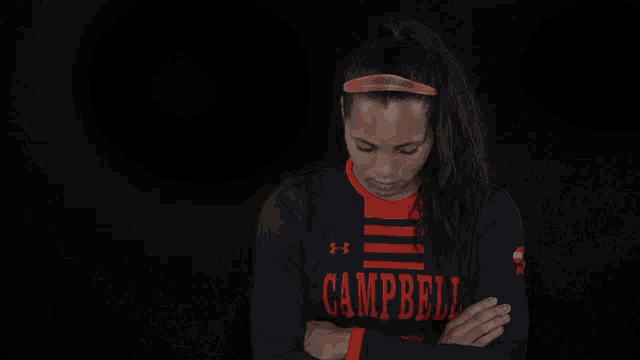 a woman with her arms crossed wears a campbell shirt