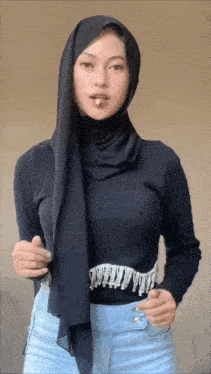 a woman wearing a black hijab and a black shirt