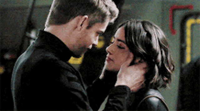 a man and a woman are looking into each other 's eyes and kissing .