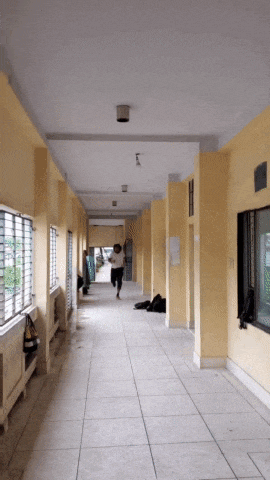 a long hallway with yellow walls and a few windows