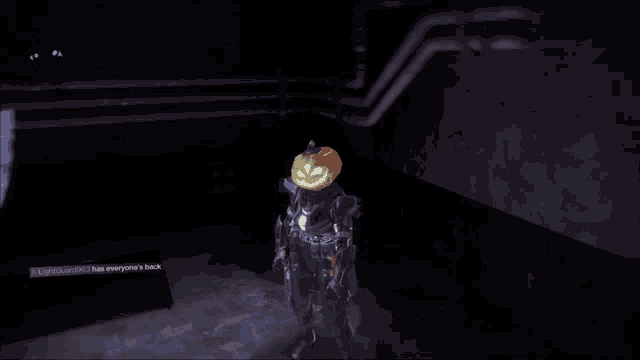 a person with a pumpkin on their head in a dark room