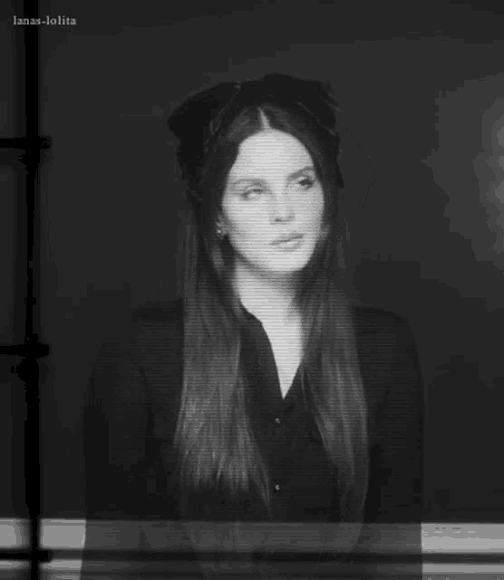 a black and white photo of lana del rey wearing a hat and a black shirt