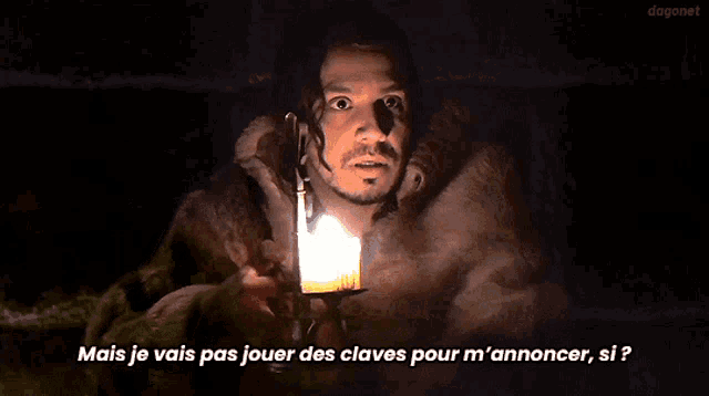 a man holding a lit candle with the words mais je vais pas jouer des claves pour m ' annoncer si