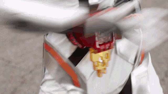 a person in a white suit is holding a sword with a red and gold emblem on it