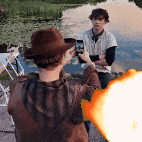 a man in a hat taking a picture of another man