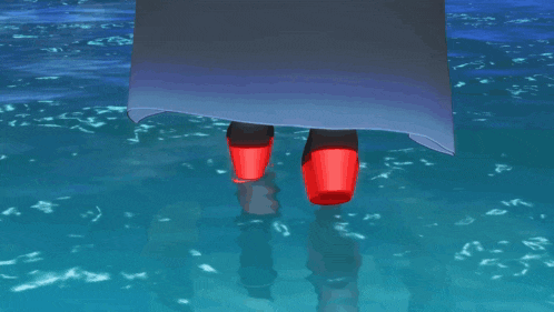 a person wearing red shoes is walking in the ocean
