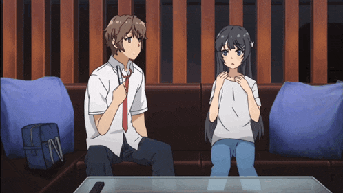 a boy and a girl are sitting on a couch looking at something
