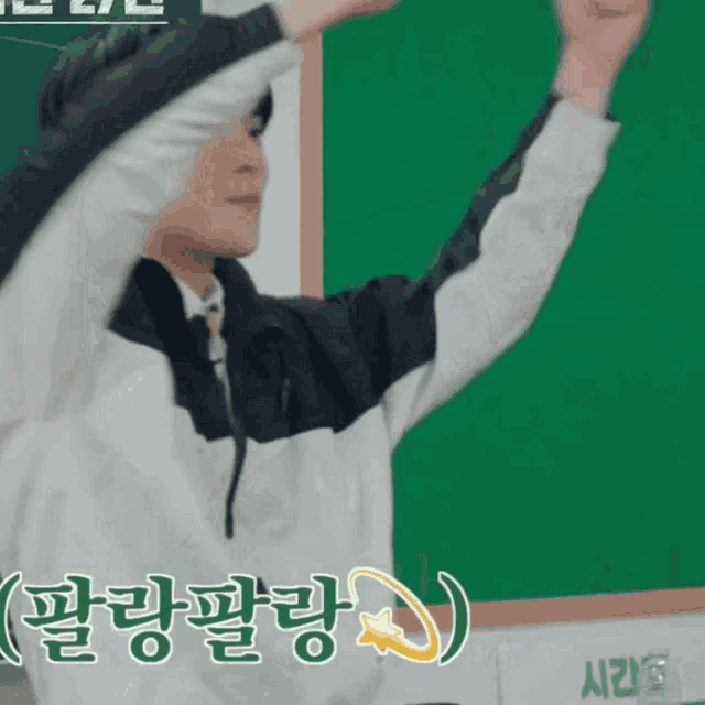 a man stands in front of a green board with chinese writing