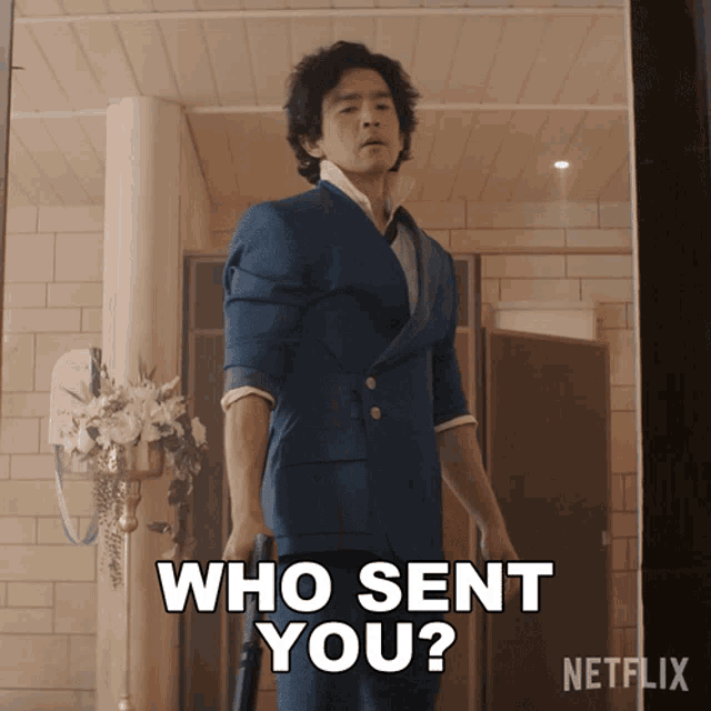 a man in a blue suit is holding a gun and says who sent you