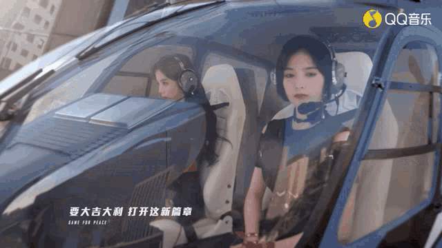 two women are sitting in a helicopter with qq written on the bottom