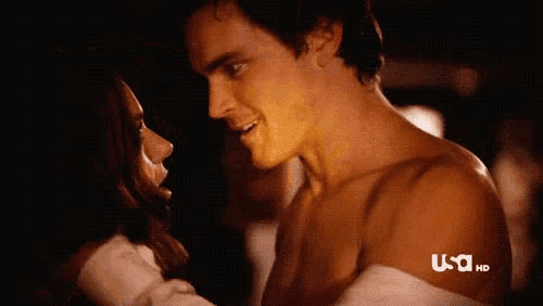 a man and a woman are kissing in a dark room with usa hd in the corner