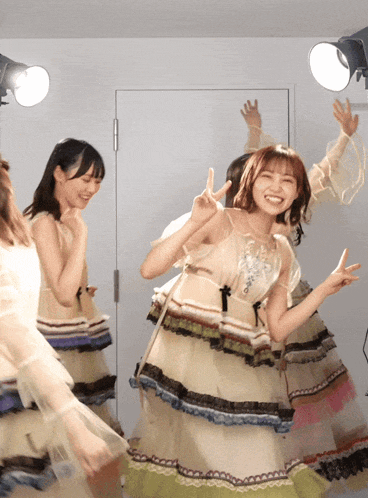 a group of young women are dancing in a room