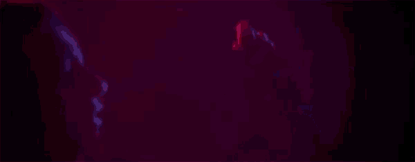 a woman is dancing in a dark room with red and blue lights behind her