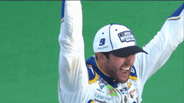 a man wearing a hat with the number 9 on it is raising his arms in the air