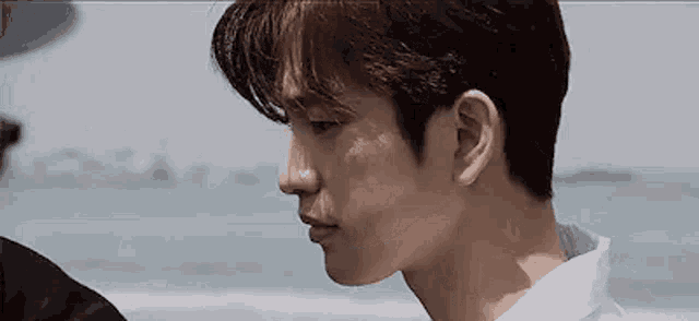 a close up of a man 's face while standing on a beach .