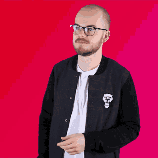 a man wearing glasses and a black jacket with a skull on the front