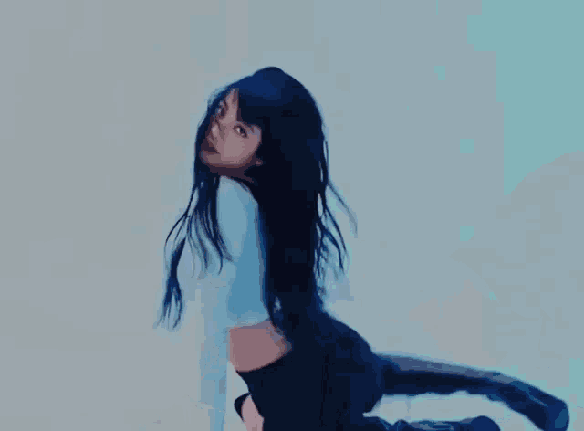 a woman in a white shirt and black shorts is laying on the floor .