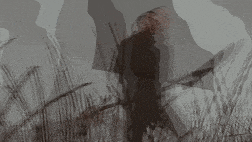 a blurred image of a person standing in a dark forest