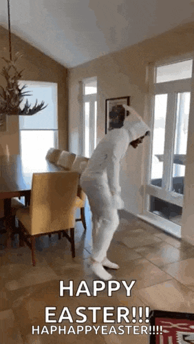 a man in a white bunny suit is dancing in a living room .