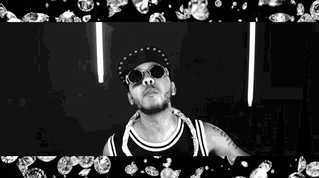 a black and white photo of a man wearing a hat and sunglasses