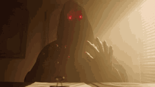 a person in a hood with red eyes is sitting at a table